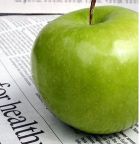 Groene appel op een krant